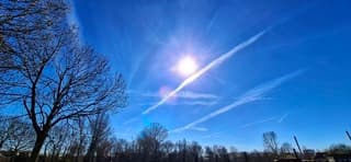 Zonnig veel blauwe lucht en vliegtuigstrepen 