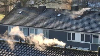 Rokende schoorstenen berijpte daken