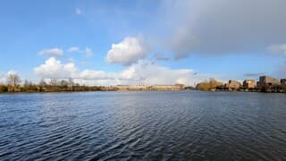 Zon, buienlucht, regen en een regenboog begin avond