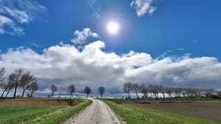 Stralende zon en wolkenlucht