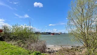 Uitzicht op de Nieuwe Maas met aan de horizon de skyline van Rotterdam 