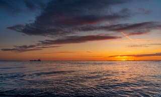 De zon verdwijnt achter de horizon