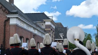 Muziekkorps onder blauwe lucht met wolken