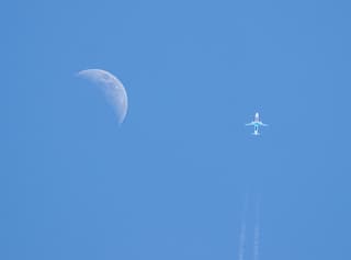 Op het juiste moment. Vliegtuig langs de maan