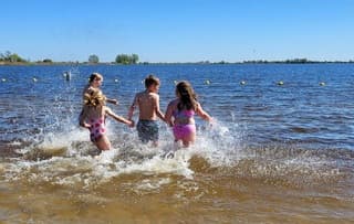 Foto 1: enthousiast rennen ze het water in.  Foto 2: en er even snel weer uit, wat is dat water koud !