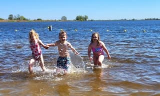 Foto 1: enthousiast rennen ze het water in.  Foto 2: en er even snel weer uit, wat is dat water koud !