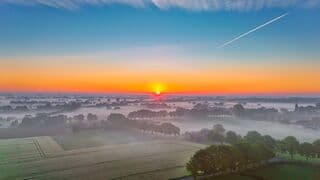  Frisse start zonsopkomst en ochtenddauw over de landerijen