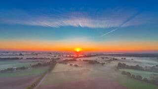 Frisse start zonsopkomst en ochtenddauw over de landerijen