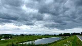 Donkere wolken boven de Waal vanmiddag in Tuil