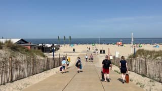 Een gestage stroom badgasten opweg naar zee en strand 