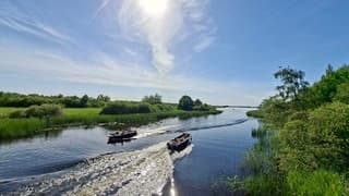 Toeristen genieten op hun bootje hier in Nationaal Park De Weerribben-Wieden 