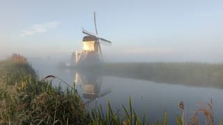 Zon, mist en molen vroeg in de ochtend 