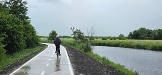 Fietser in een regenbui in de provincie Groningen vanmiddag 