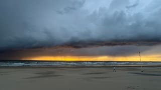Explosieve wolken boven zee bij zonsondergang