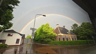 dubbele regenboog tegen onweersbui
